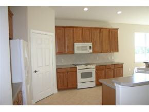 1281 Rialto Way, Unit 201 Naples, FL 34114 - Photo 2 of 6 a kitchen with granite countertop white cabinets and stainless steel appliances
