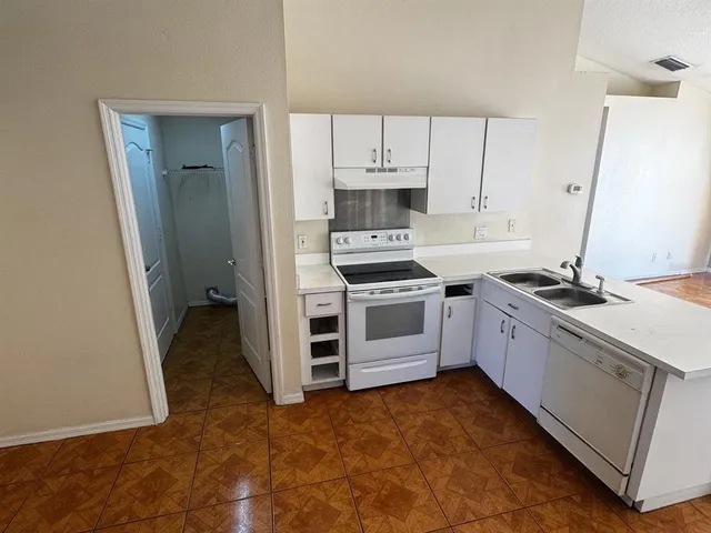 a kitchen with a sink stove and cabinets