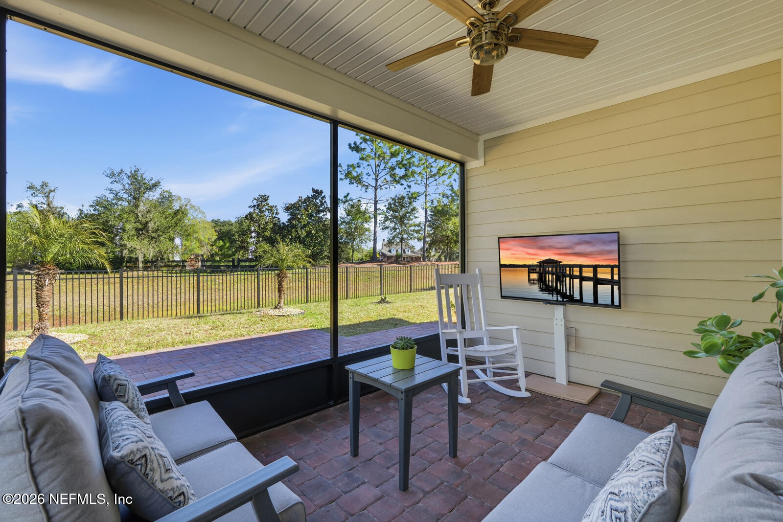 979 Rustic Ml Drive St. Augustine, FL 32092 - Photo 26 of 46 a living room with couches a flat screen tv and a floor to ceiling window with a flat screen tv