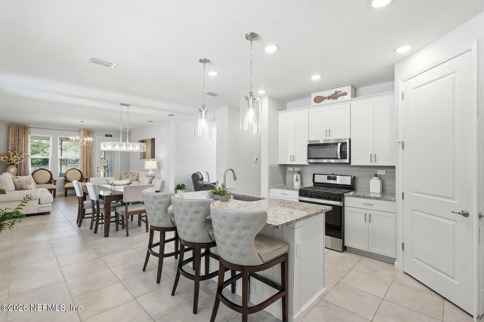 979 Rustic Ml Drive St. Augustine, FL 32092 - Photo 7 of 46 a kitchen with stainless steel appliances kitchen island granite countertop a stove a sink a dining table and chairs