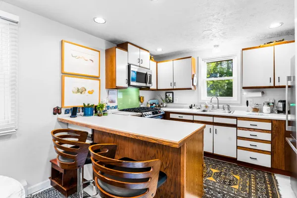 a kitchen with stainless steel appliances a sink a stove and a microwave