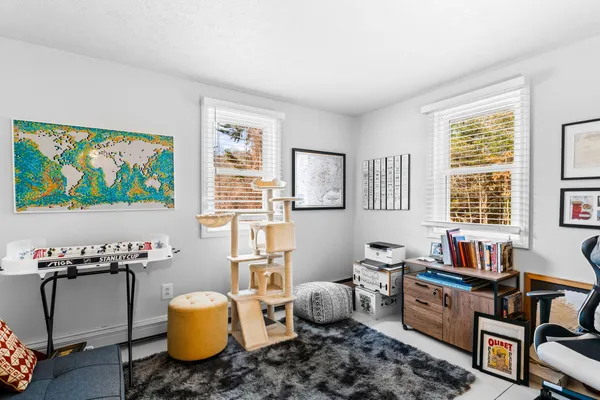 a bedroom with a bed and a dresser next to a window