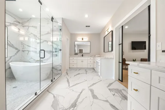a bathroom with a tub sink and mirror