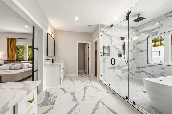 a bathroom with a tub sink shower and mirror