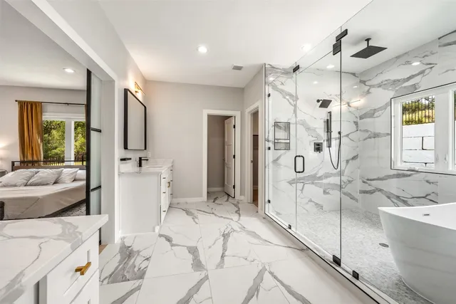 a bathroom with a tub sink shower and mirror