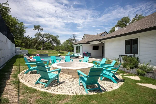 a front view of a house with garden chairs and fire pit