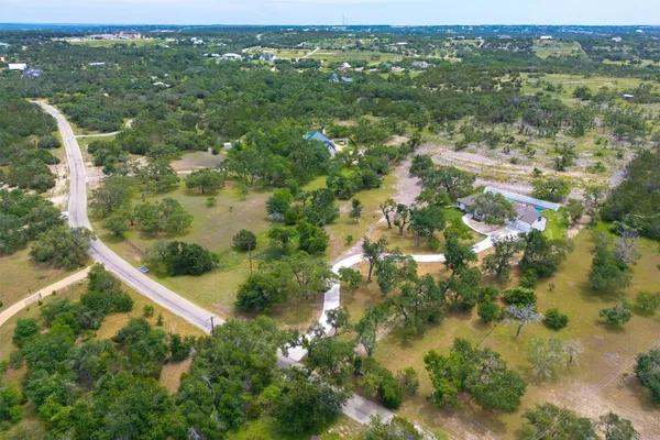 an aerial view of residential houses with outdoor space and trees