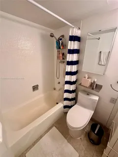 a white toilet sitting next to a bath tub and shower