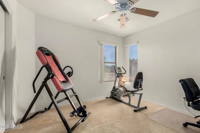 a view of a workspace with furniture and a ceiling fan