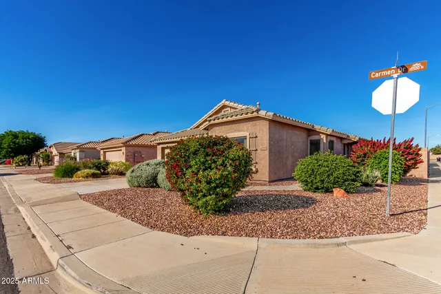 a front view of a house with a yard and potted plants