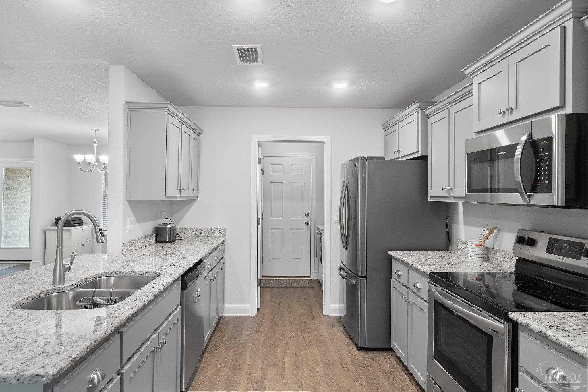 1463 Promenade Loop Cantonment, FL 32533 - Photo 15 of 41 a kitchen with stainless steel appliances granite countertop a sink stove and refrigerator