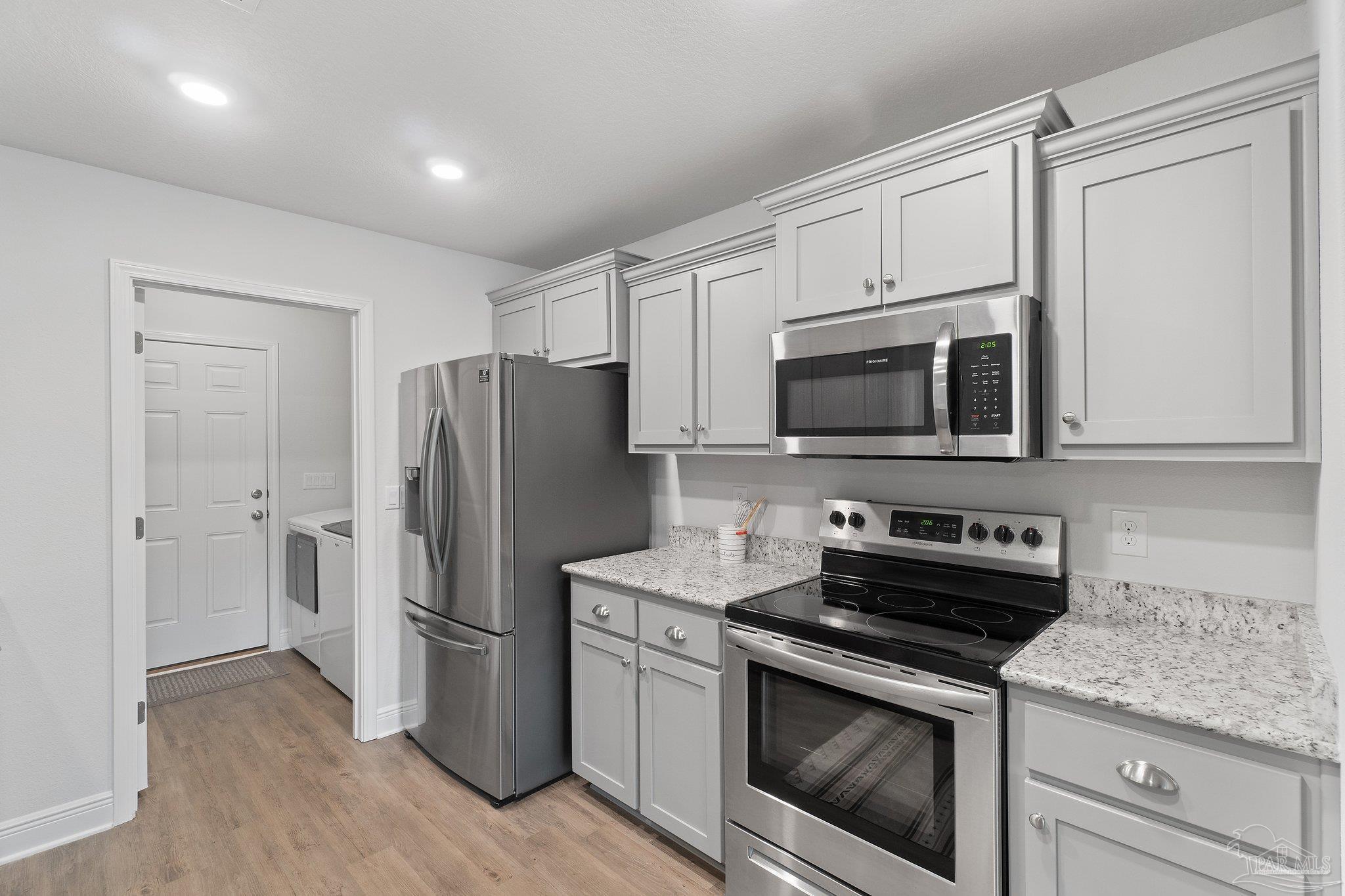 1463 Promenade Loop Cantonment, FL 32533 - Photo 17 of 41 a kitchen with stainless steel appliances white cabinets and a stove top oven