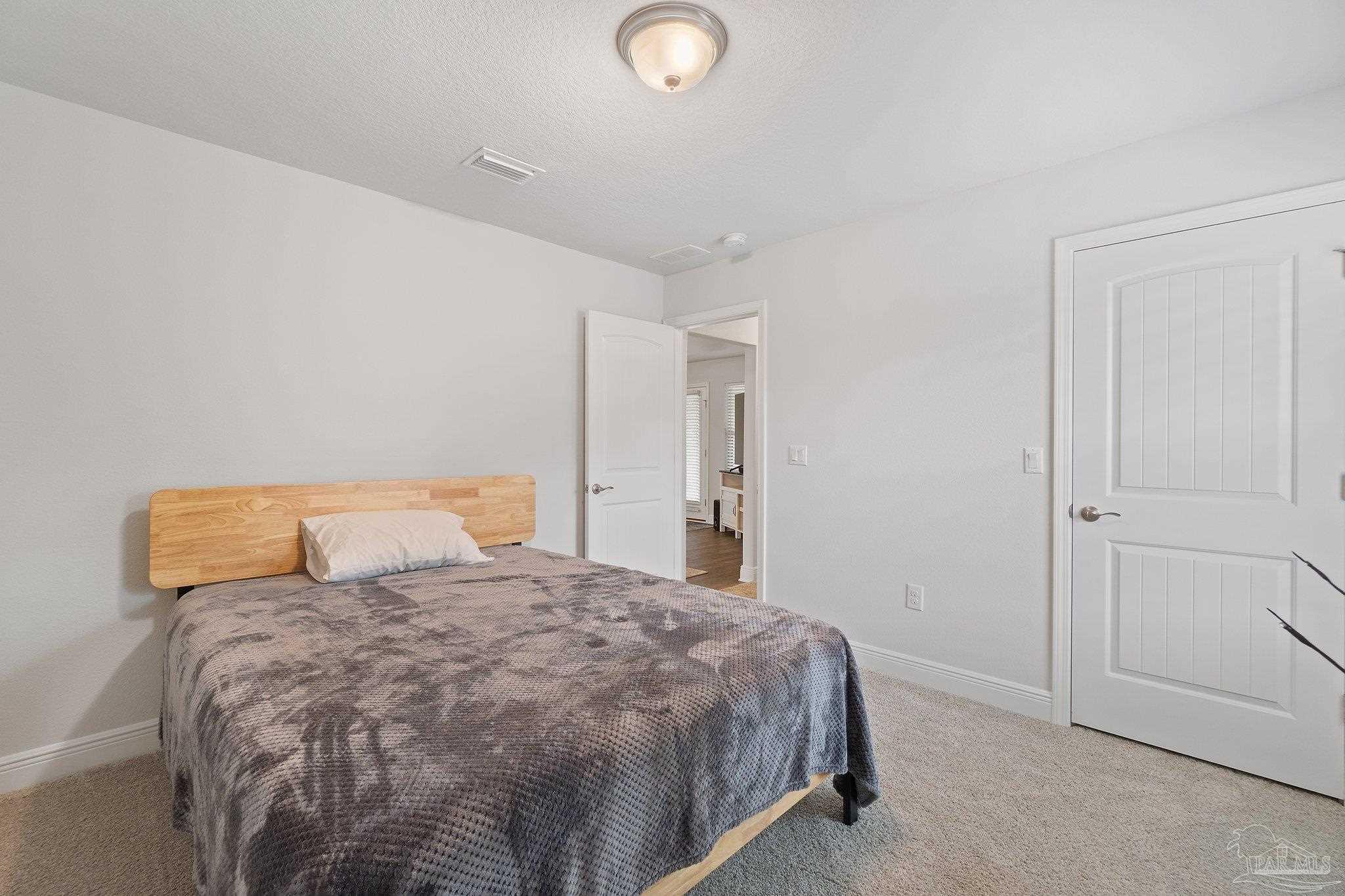 1463 Promenade Loop Cantonment, FL 32533 - Photo 31 of 41 a bedroom with a bed and a lamp