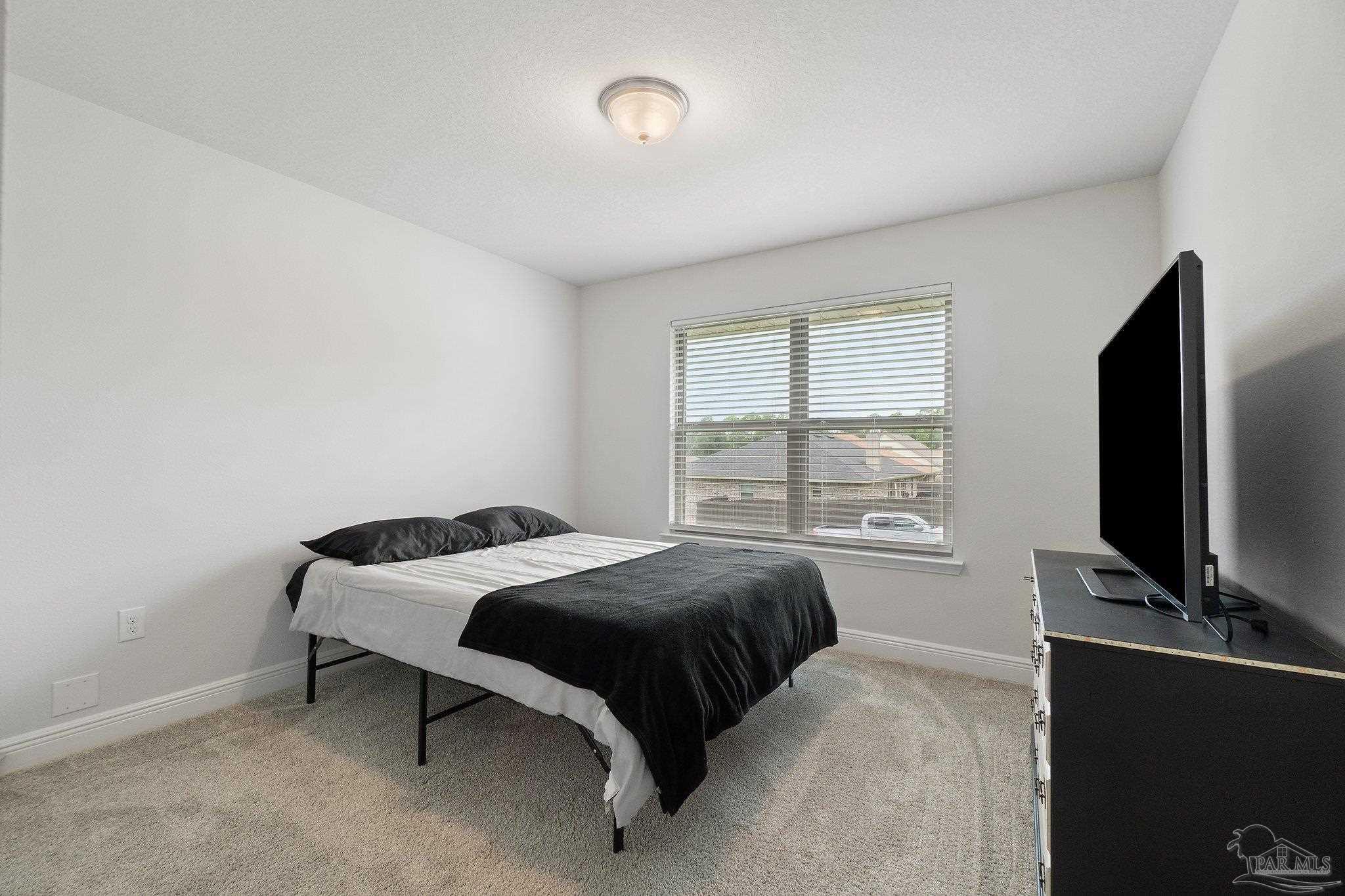 1463 Promenade Loop Cantonment, FL 32533 - Photo 33 of 41 a bedroom with a bed and a flat tv screen on the dresser