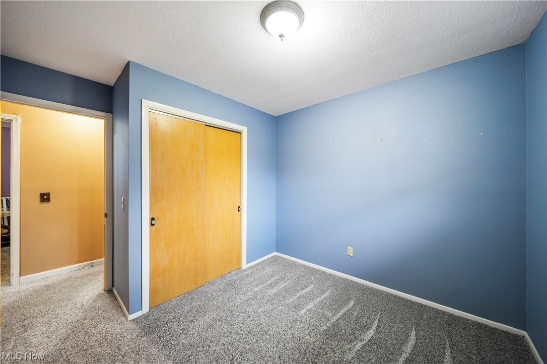 9944 Hoose Road Mentor, OH 44060 - Photo 14 of 35 Unfurnished bedroom featuring light carpet, a closet, and a textured ceiling