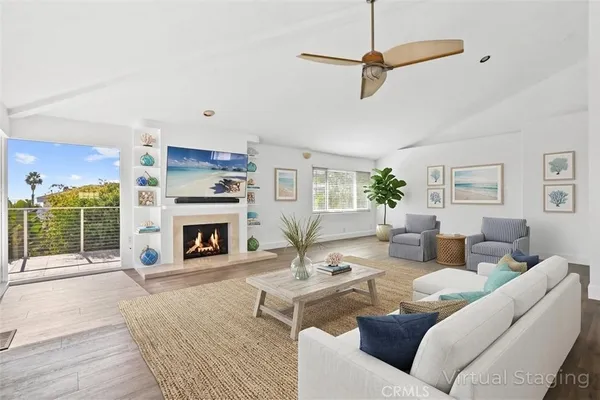 a living room with furniture a fireplace and a chandelier