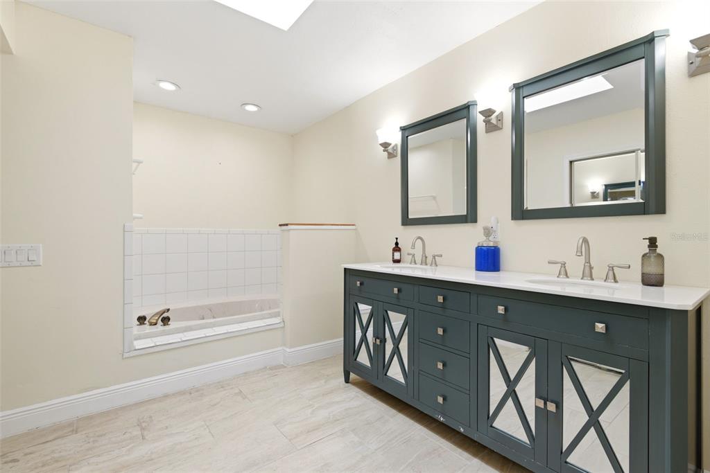 7432 Sparkling Lake Road Orlando, FL 32819 - Photo 25 of 54 a bathroom with a double vanity sink mirror and bathtub