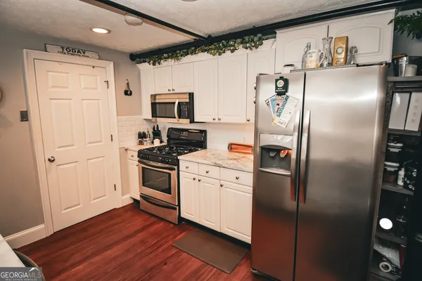 a kitchen with stainless steel appliances a refrigerator sink and microwave