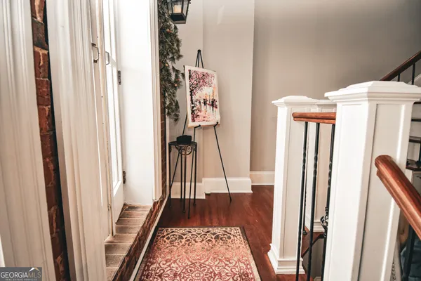 a view of a hallway with wooden floor and staircase