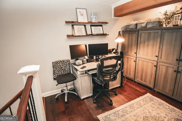 a view of a workspace with furniture and wooden floor