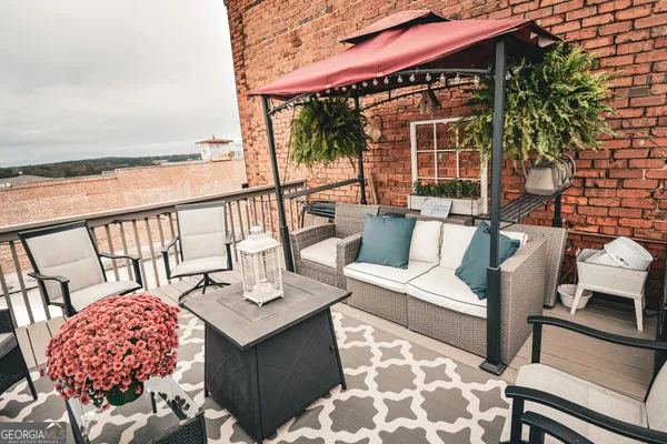 a balcony with furniture and wooden floor