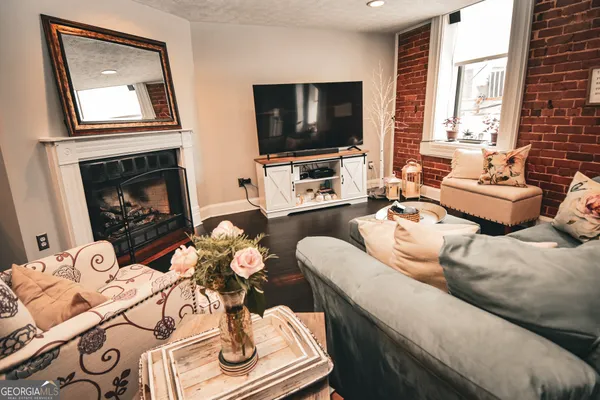 a living room with furniture a fireplace and a flat screen tv