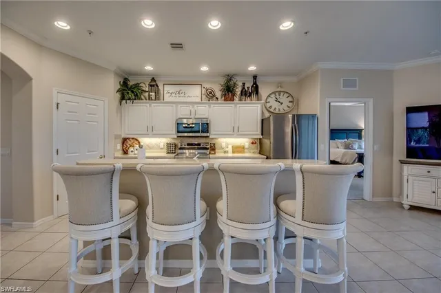 a kitchen with a dining table chairs stainless steel appliances cabinets and a counter top space