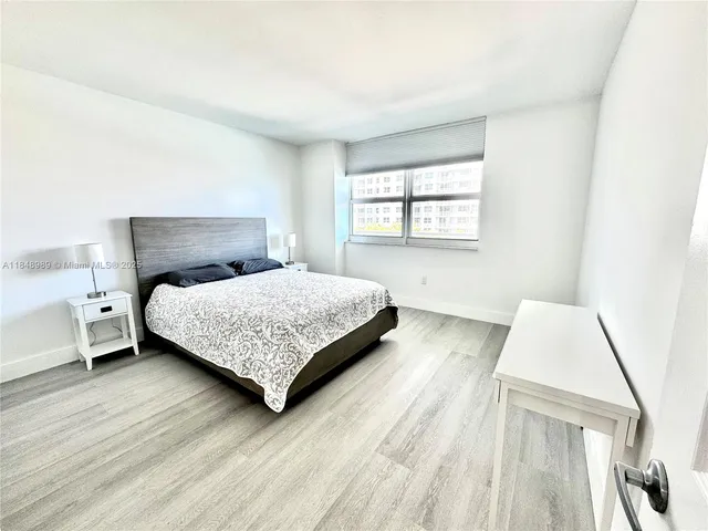 a bedroom with a bed lamp and a large window