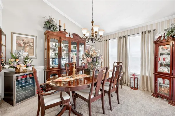a view of a dining room with furniture a chandelier and a window