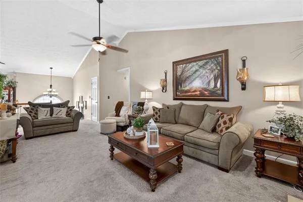 a living room with furniture a couch and paintings on the wall