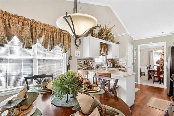 a dining room with furniture a potted plant and wooden floor