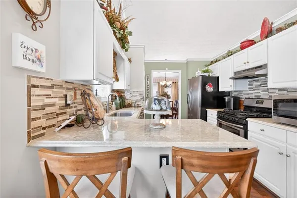 a kitchen with stainless steel appliances granite countertop a sink a stove and a refrigerator