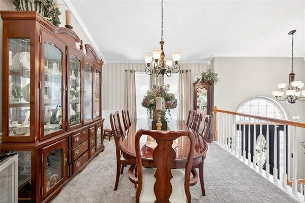 a dining room with furniture a chandelier and wooden floor