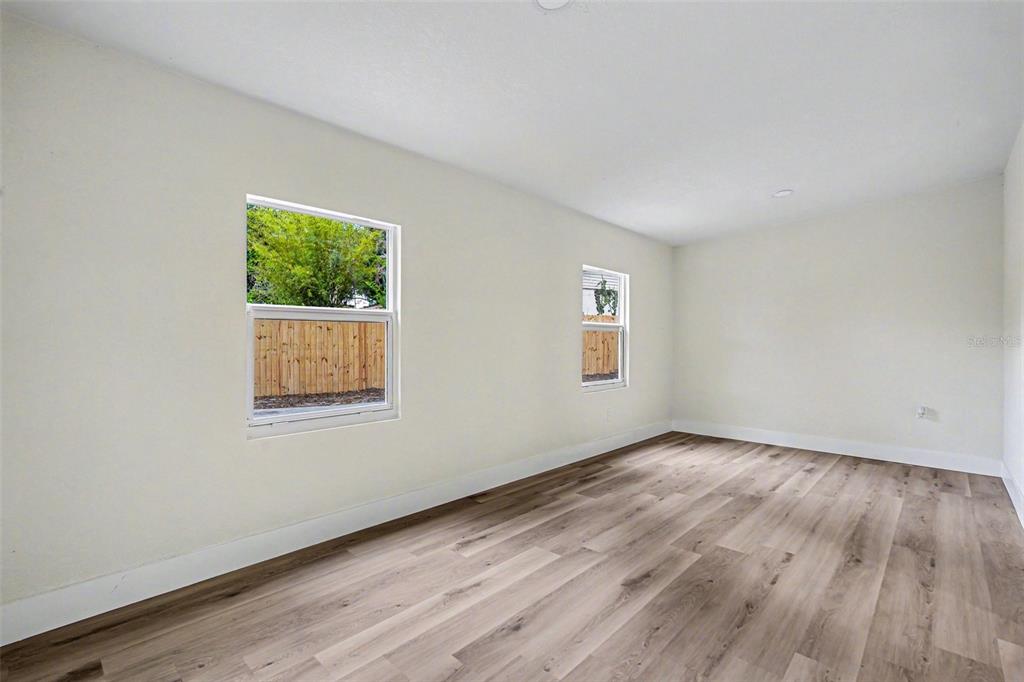 707 Queens Court Seffner, FL 33584 - Photo 18 of 28 a view of an empty room with wooden floor and a window