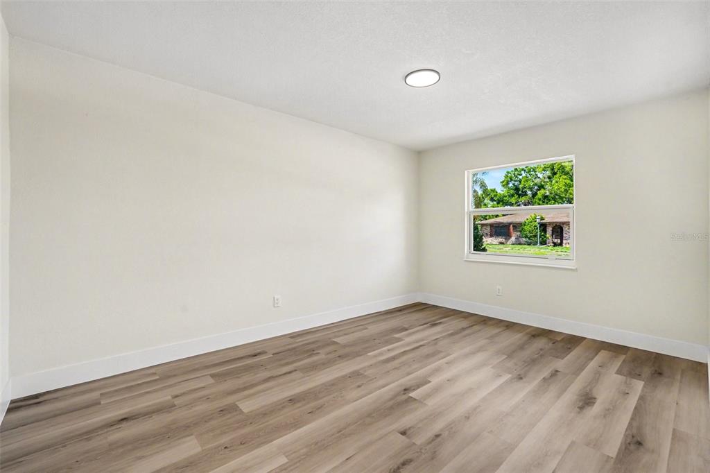 707 Queens Court Seffner, FL 33584 - Photo 19 of 28 an empty room with wooden floor and window