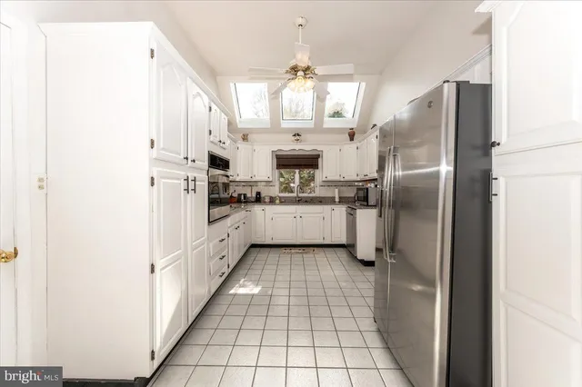 a kitchen with granite countertop white cabinets and white appliances