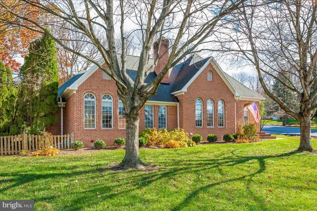 a front view of a house with a yard and trees