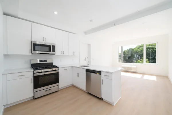 a kitchen with stainless steel appliances granite countertop a stove a sink and a microwave