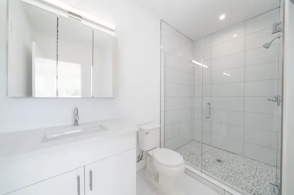 a bathroom with a sink a toilet and shower