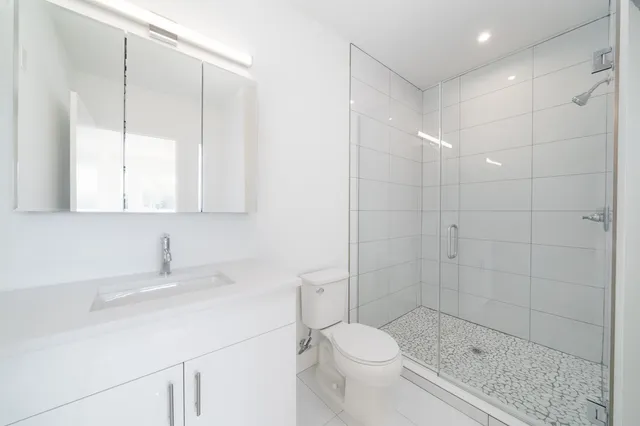 a bathroom with a sink a toilet and shower