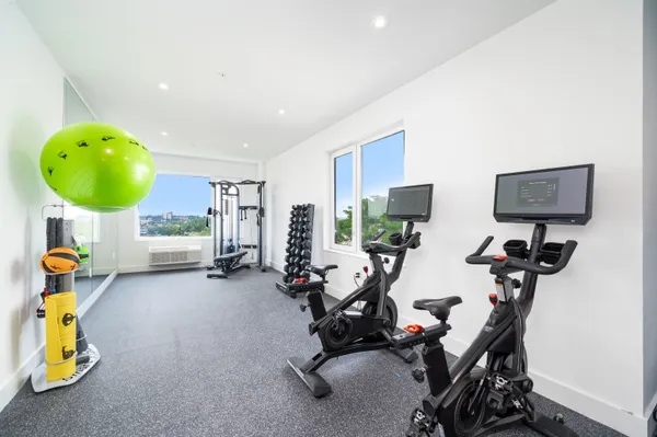 a view of a room with gym equipment and floor to ceiling window