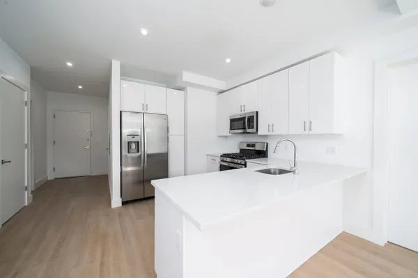 a kitchen with stainless steel appliances a refrigerator sink and microwave