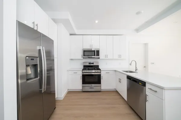 a kitchen with stainless steel appliances granite countertop a refrigerator and a sink