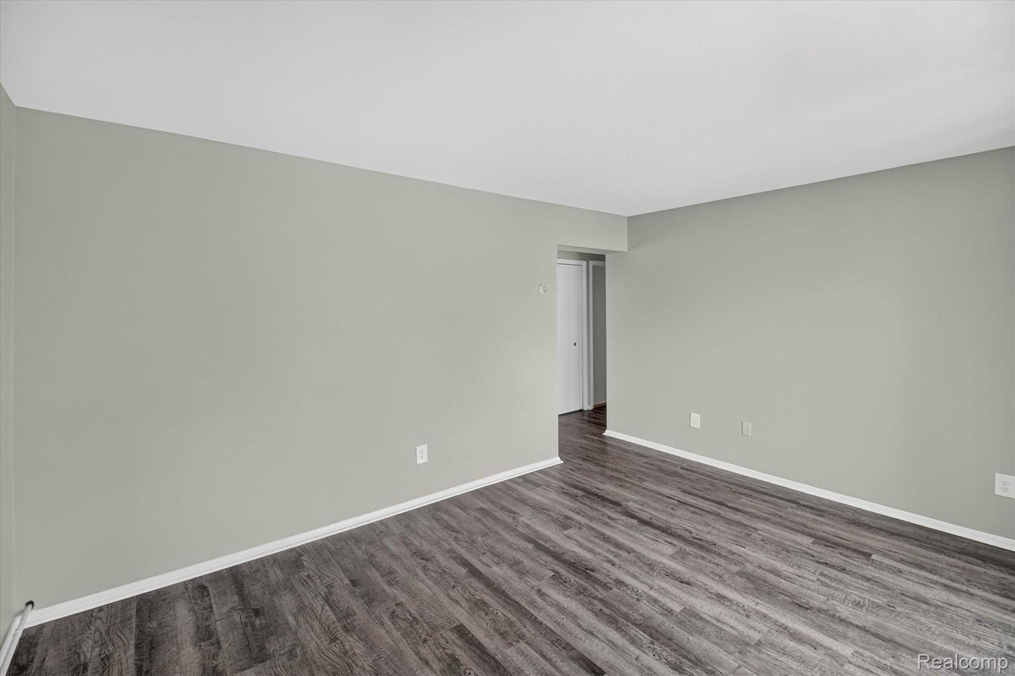 22000 Beck Road, Unit 101 Northville, MI 48167 - Photo 6 of 20 Light gray wall paint with white trim, wood-finish flooring, and white ceiling