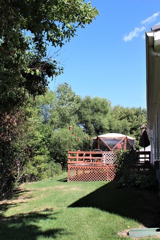 13806 Prairie Center Road Morrison, IL 61270 - Photo 4 of 24 a view of a patio with lawn chairs under an umbrella