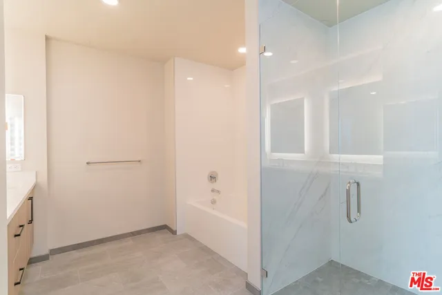 a bathroom with a shower sink and mirror