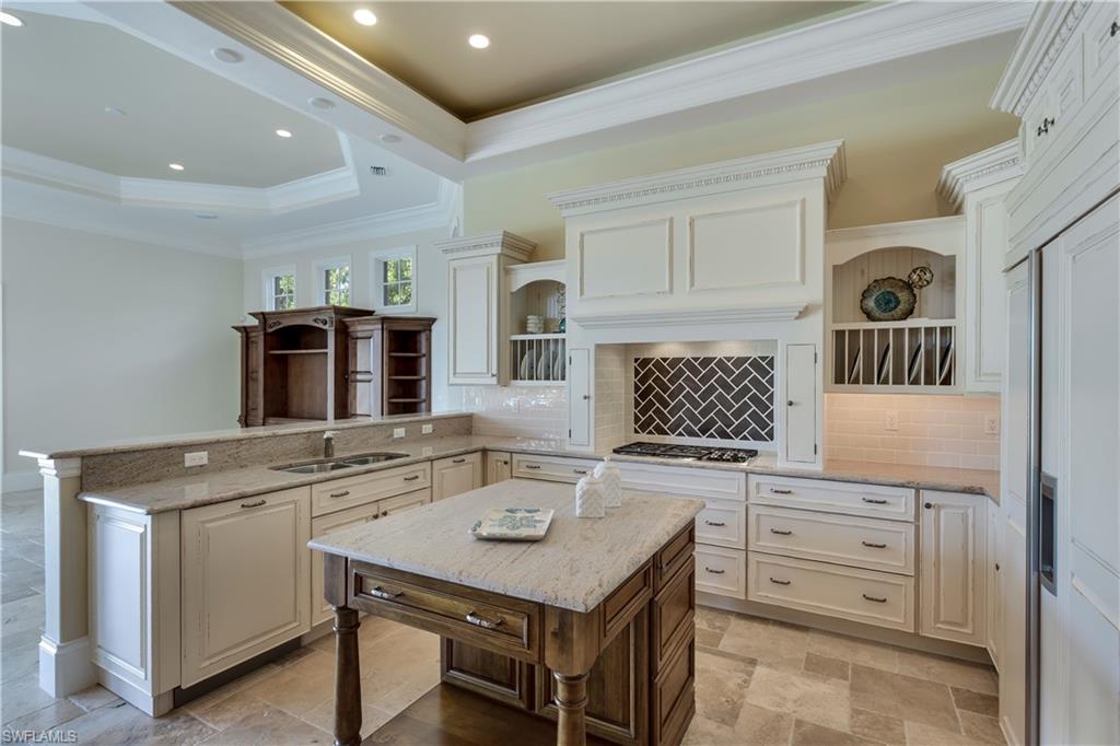 3875 Isla Del Sol Way Naples, FL 34114 - Photo 13 of 24 a kitchen with a stove a sink and a refrigerator
