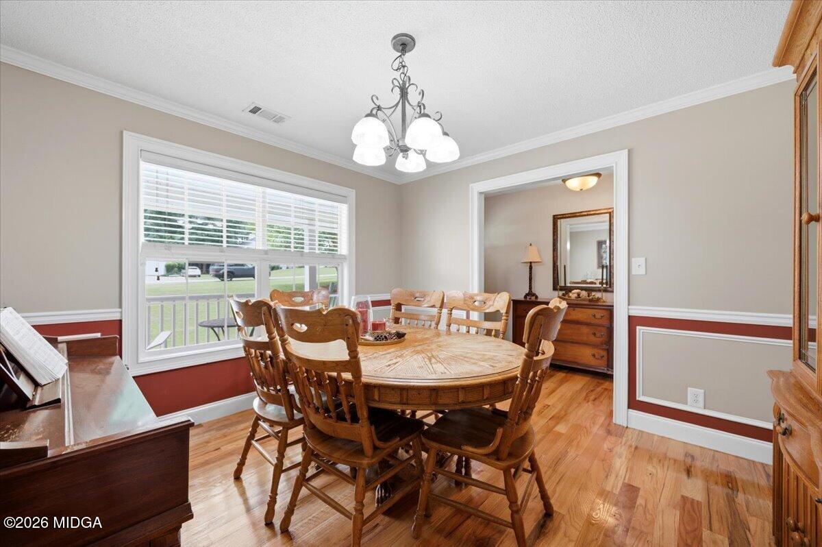 557 Aarons Circle Gray, GA 31032 - Photo 16 of 36 a view of a dining room with furniture wooden floor and chandelier
