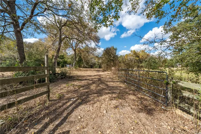 a view of a yard with wooden fence