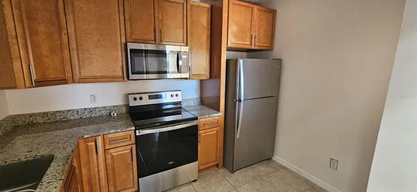 a kitchen with stainless steel appliances granite countertop a refrigerator stove and microwave